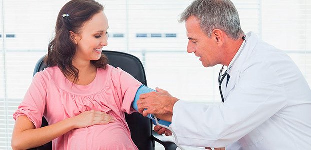 доктор измеряет беременной давление