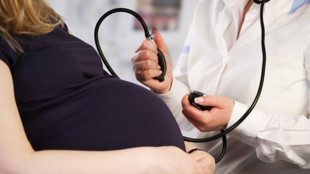 врач измеряет беременной девушке давление